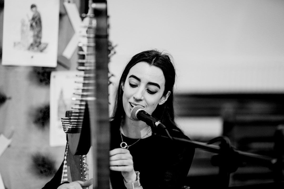 Claire Heffernan singing and playing the harp at a wedding ceremony.