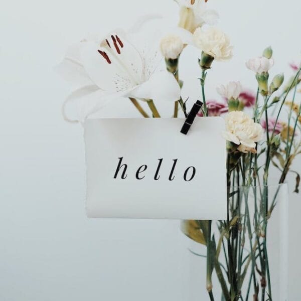 Bouquet of flowers with a small card reading ‘hello’ attached.